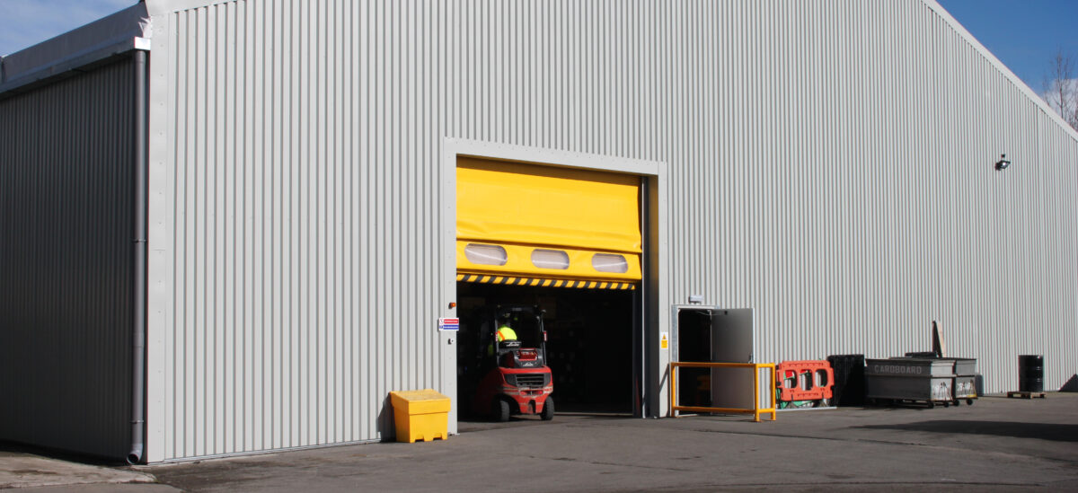 Spaciotempo temporary warehouse with yellow roller shutter door