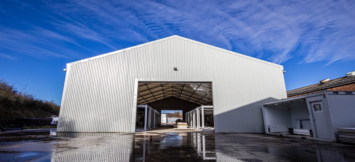 Side of a winter ready temporary warehouse with open rolling door