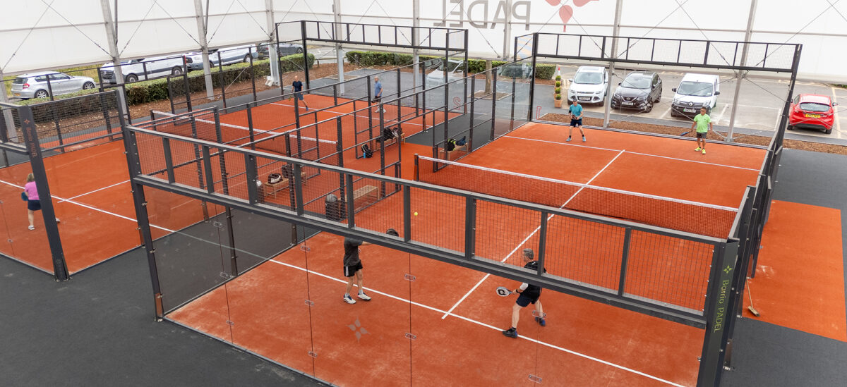 a temporary building around 4 padel courts with people playing