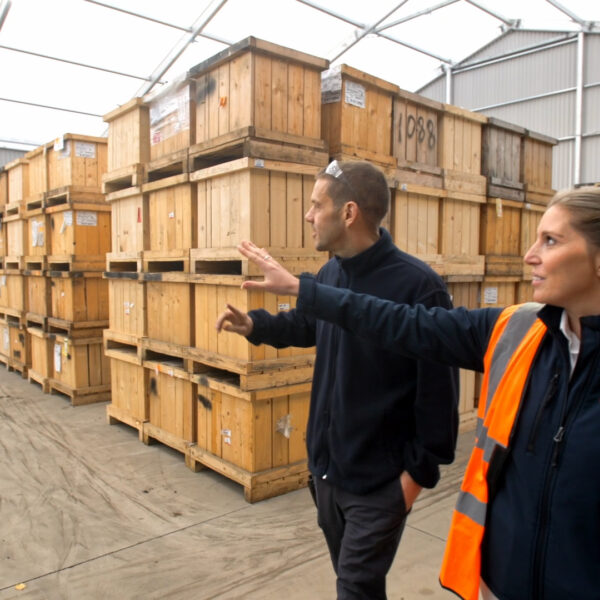 two workers walking through storage within a temporary warehouse
