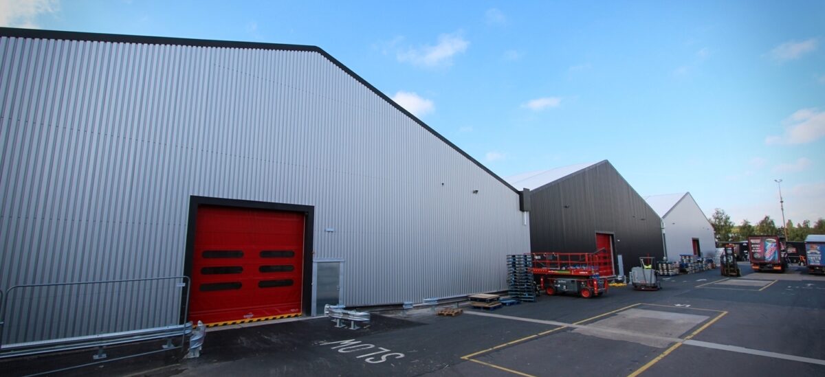 three large temporary buildings connected with red vehicle doors
