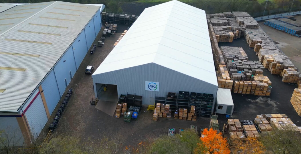 temporary Spaciotempo from above within a yard with many stock stored around the building