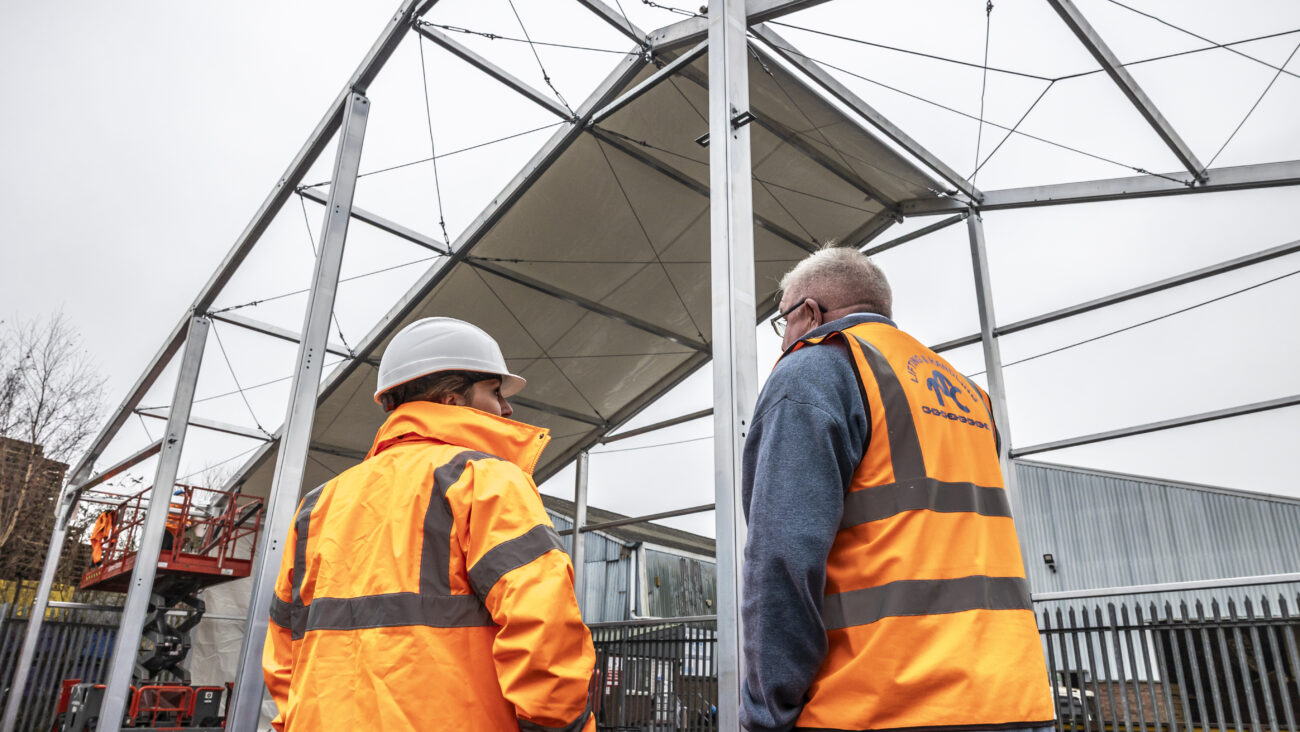 temporary structure mid build with two workers in high-vis