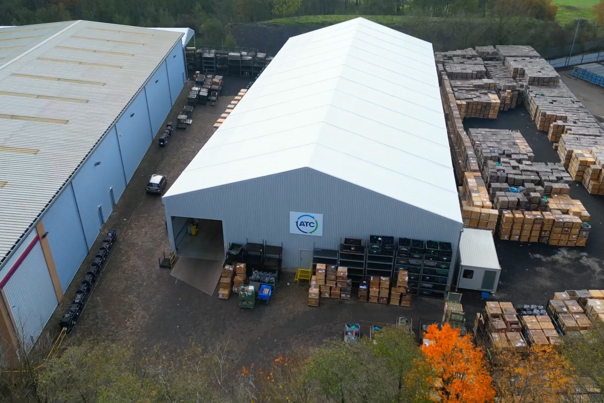 temporary Spaciotempo from above within a yard with many stock stored around the building