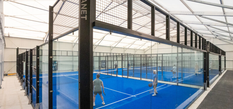 view of padel courts from the side with players playing padel